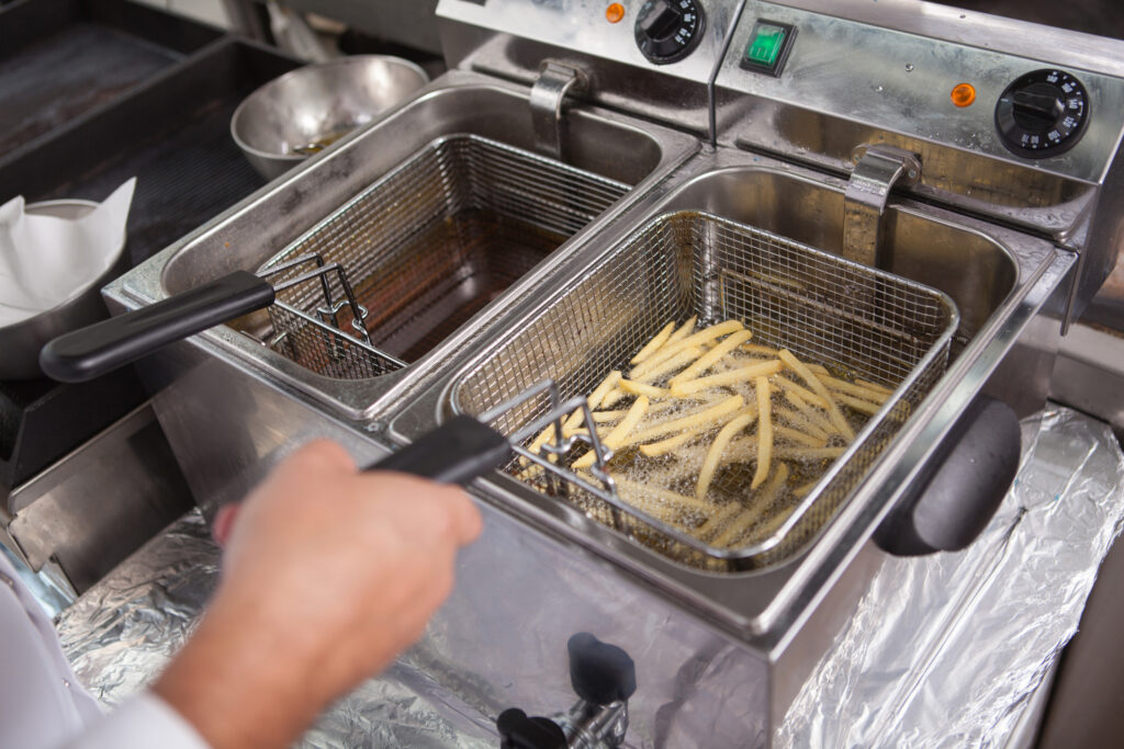 Commercial Fryer Repair Guide: Troubleshooting Tips & Maintenance - fries in oil - Eleven36 Blog