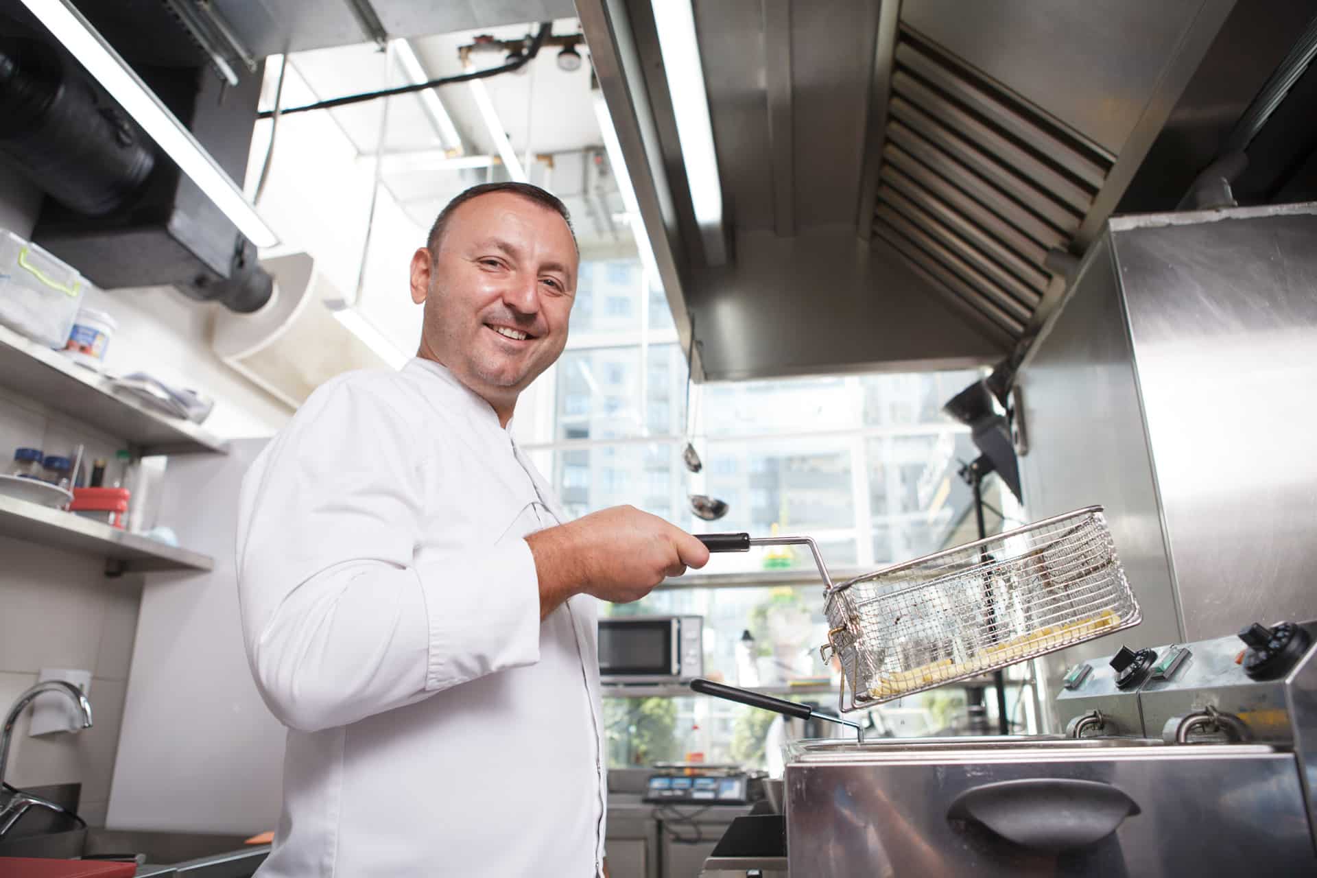 Chef lifting a Fry Basket out of a Deep Fryer