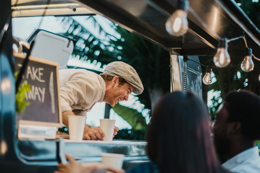 Happy food truck owner serving guests
